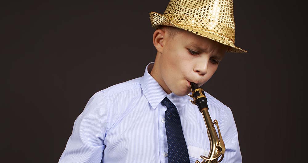 boy in hat playing saxophone